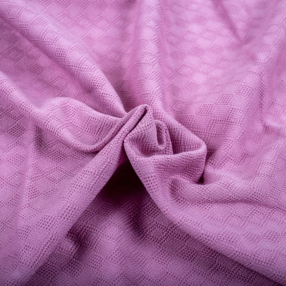 Orchid-pink jacquard knit with a raised honeycomb diamond pattern, gathered into folds.